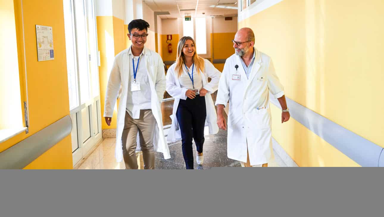 Students walking through the hospital hallway with a doctor.
