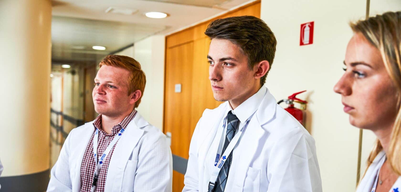 Students listening intently while shadowing in a hospital.