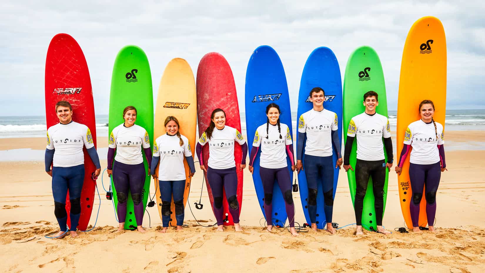 Students lined up with surfboards on the beach. (Lisbon, 2019)