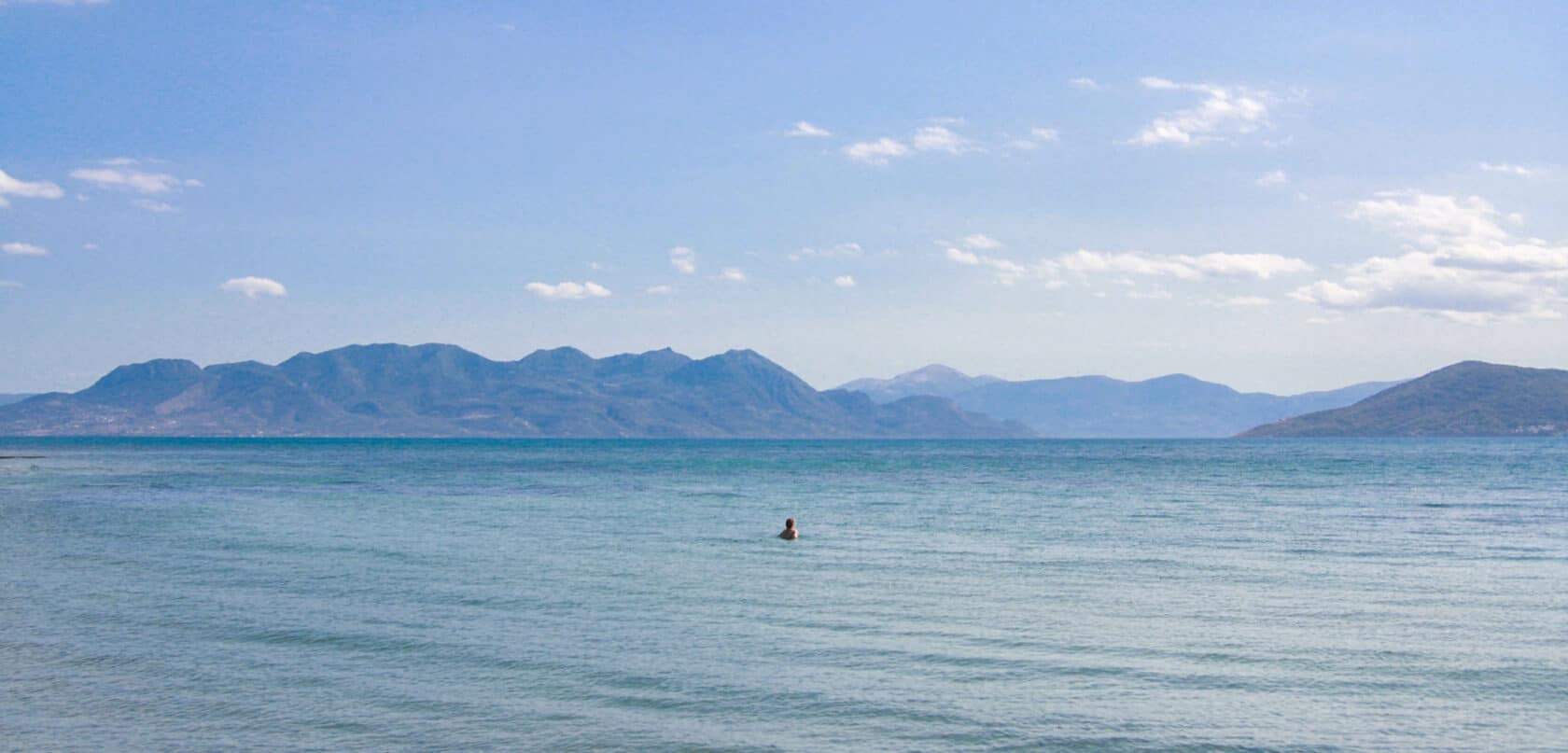 A view of the ocean with mountains in the background.
