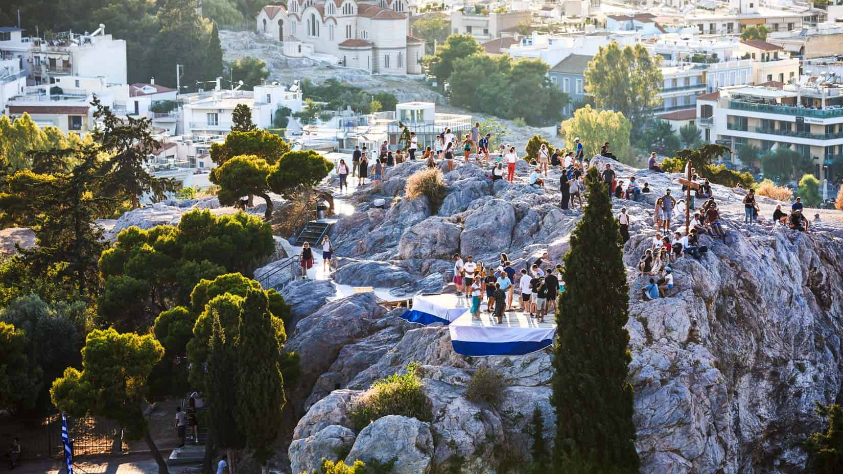 Students on a rock to view the city of Athens from above.